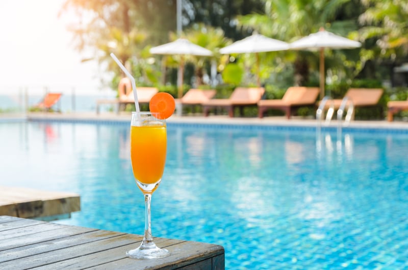 Enjoying swimming pool and cocktail during leisure travel at hotel